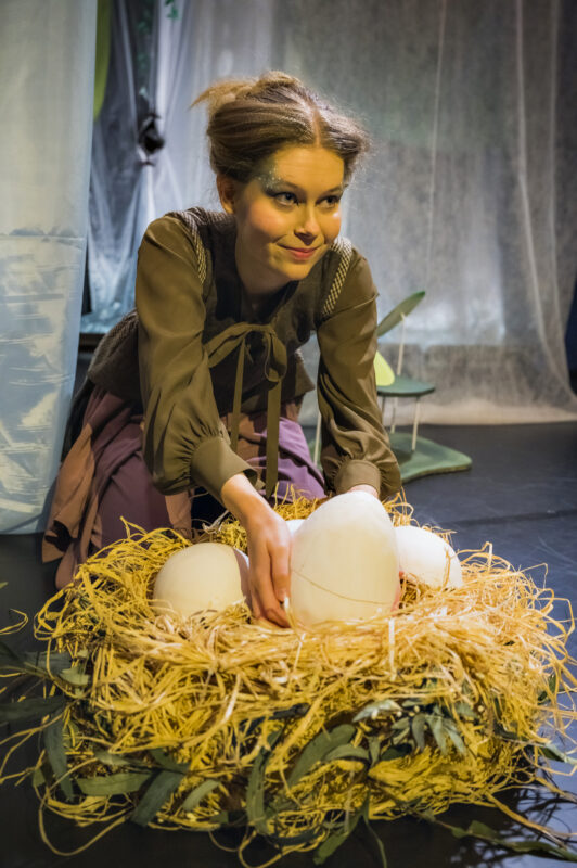 Kvinne på scenen foran et fuglerede med store egg