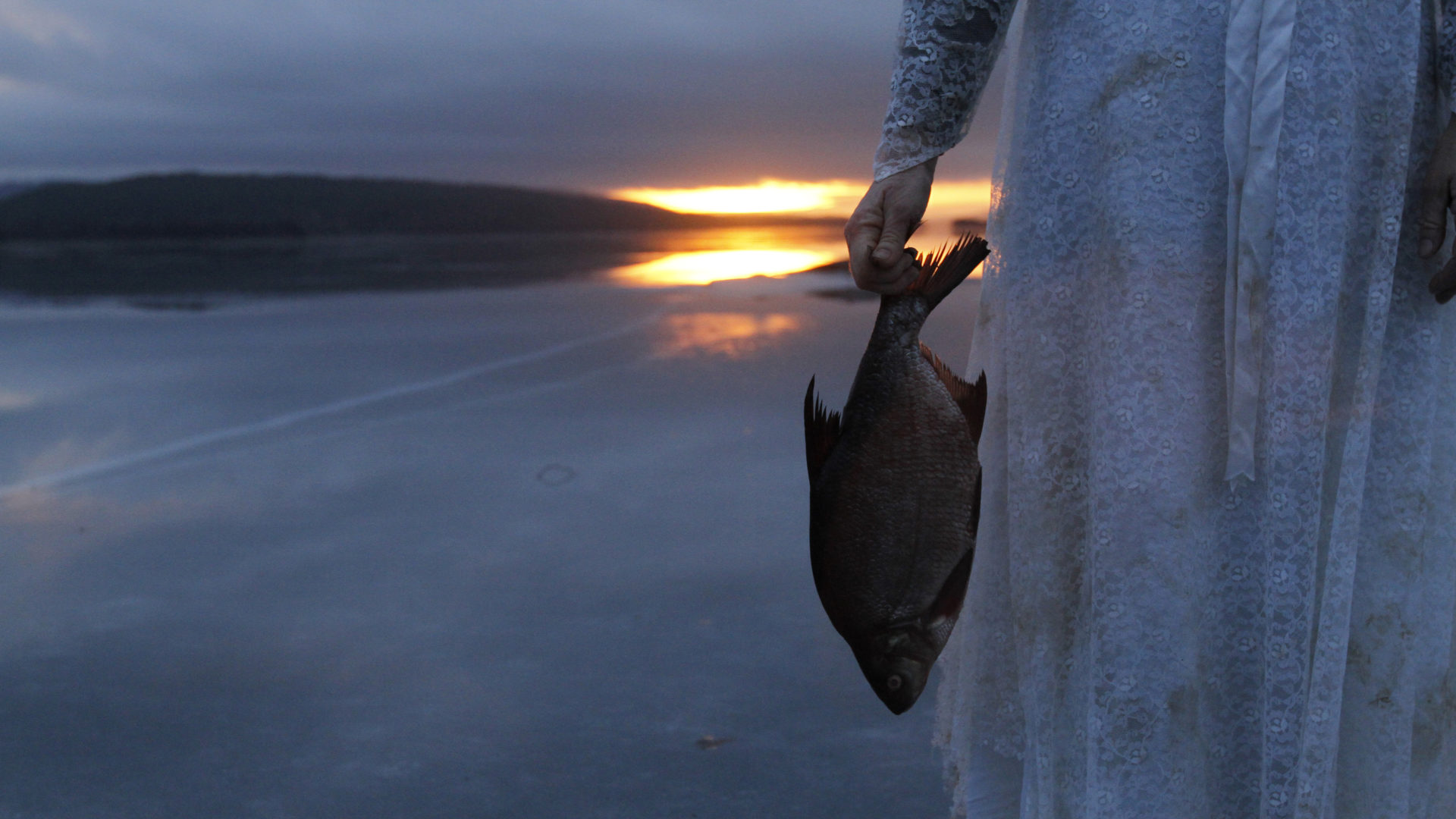 Dame holder en død fisk