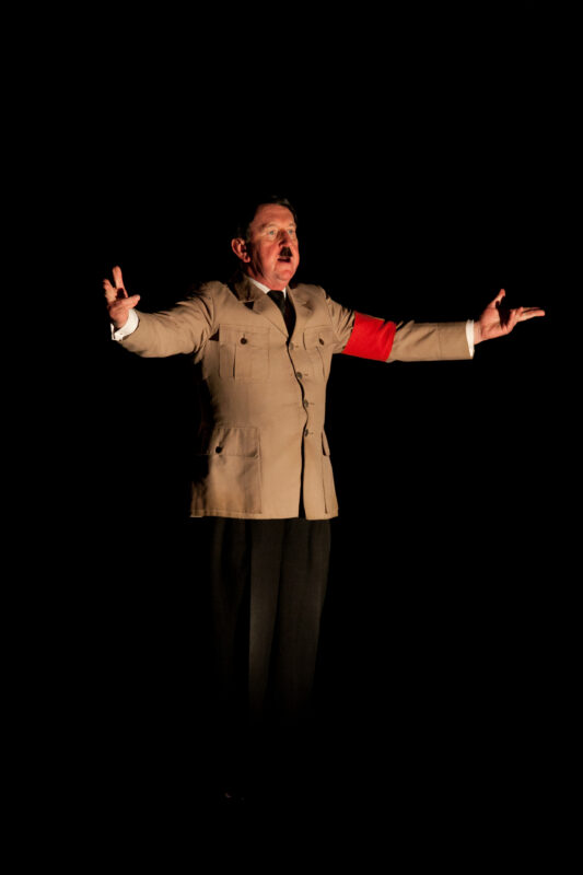 Pip Utton som Hitler, med armene ut til siden.
