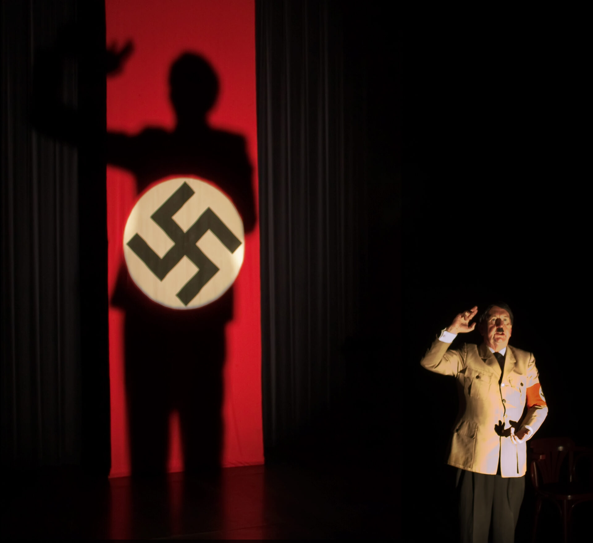 Pip Utton som Hitler, med nazi-banner til venstre