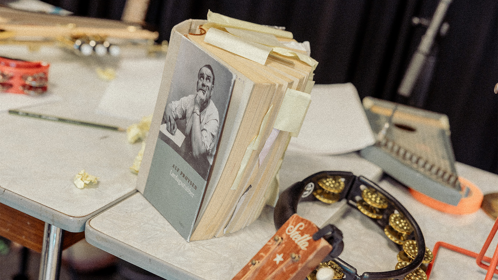 Bok med tittelen Prøysens stubber som står på et bord. På orde er det også insturmenter.