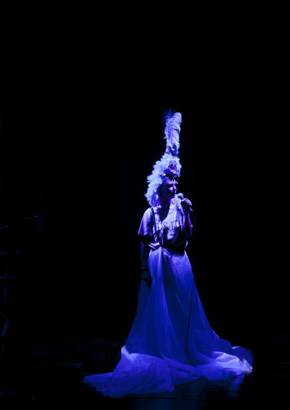 Kvinne med lang kjole alene på scenen