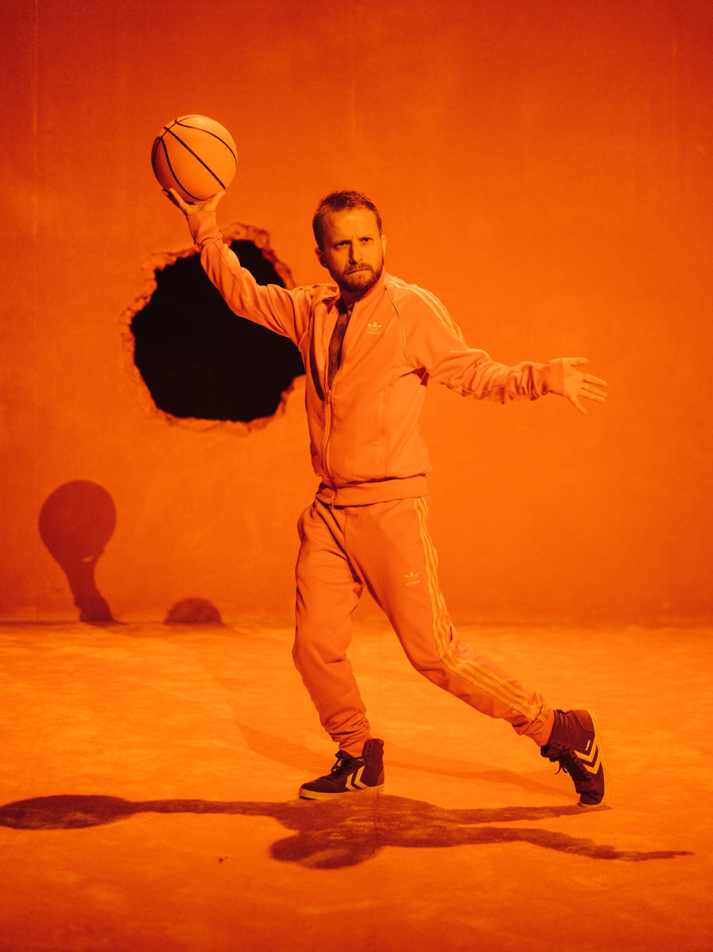 Mann med treningstøy og basketball i hånda.