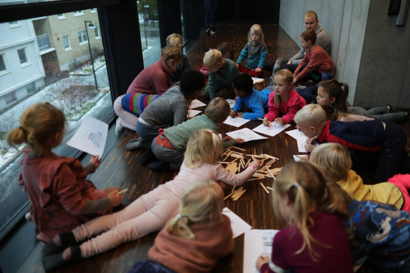 Barn som ligger på gulvet og tegner