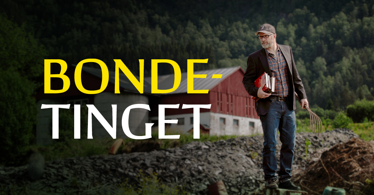 En mann står på et jorde og holder i bøker med den ene hånda. Bak han står det en låve.